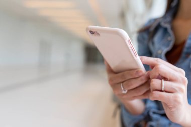 Alışveriş merkezinde Smartphone kullanan kadın