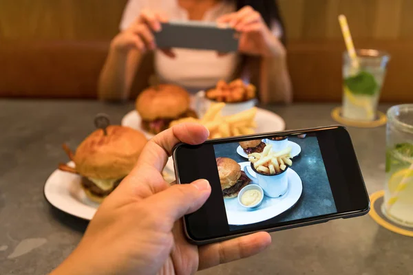 Фотография на мобильный телефон в ресторане — стоковое фото