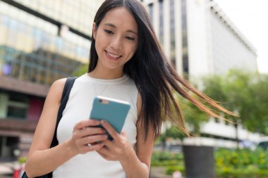 Şehirde akıllı telefon kullanan bir kadın.