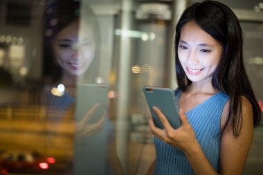 Gece akıllı telefon kullanan bir kadın.