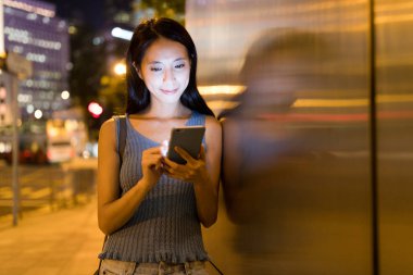 Smartphone şehirde geceleri kullanan kadın 