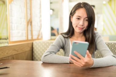 Restauarnt içinde cep telefonu kullanan kadın 