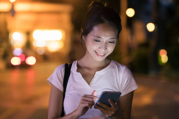 Mulher usando celular à noite — Fotografia de Stock