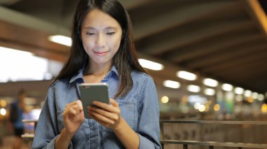 Geceleri cep telefonu kullanan bir kadın.