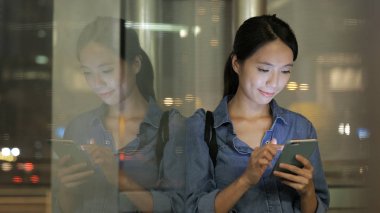 Geceleri cep telefonu kullanan bir kadın. 