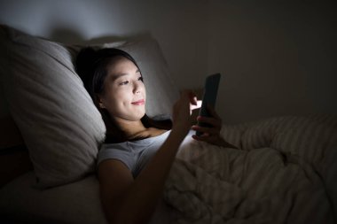 Geceleri cep telefonu kullanan kadın