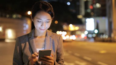 Cep telefonu kullanarak ve taksi için bekleyen iş kadını