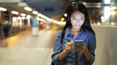 Geceleri cep telefonu kullanan bir kadın.