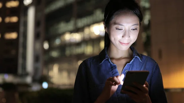 Frau nutzt abends Smartphone — Stockfoto