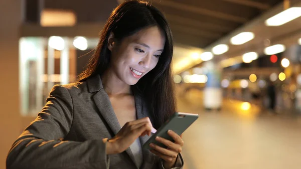 Femme d'affaires regardant sur le téléphone mobile la nuit — Photo