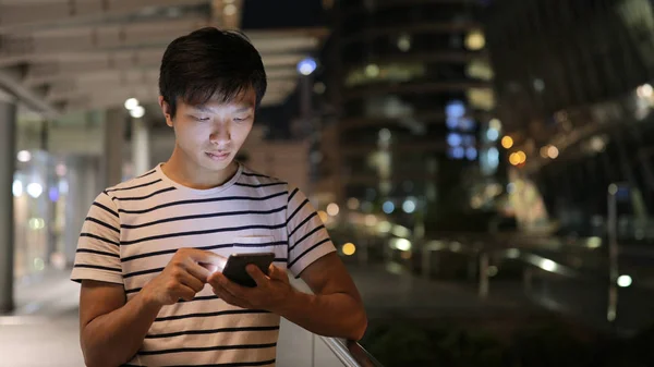 Hombre joven usando teléfono móvil — Foto de Stock