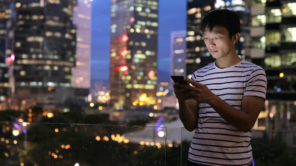 Asiático hombre usando celular en la noche —  Fotos de Stock