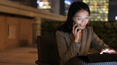 Tablet bilgisayar kullanarak ve telefonda konuşurken işkadını