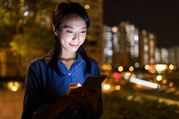 Mulher usando telefone celular à noite — Fotografia de Stock