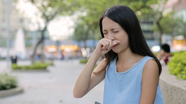 Женщина чихает на открытом воздухе — стоковое фото