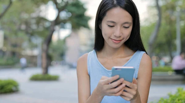 Vrouw met smartphone in de stad — Stockfoto