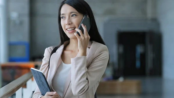 Affärskvinna talar på mobiltelefon och håller tablet PC — Stockfoto