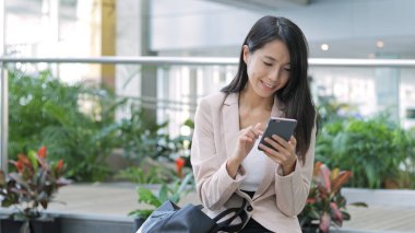 Ofiste cep telefonu kullanan iş kadını 