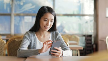 Restoranda cep telefonu kullanan kadın 