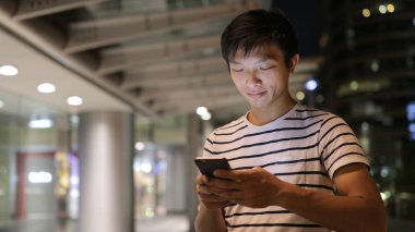 Genç adam cep telefonu kullanıyor.