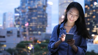 Geceleri cep telefonu kullanan genç kadın