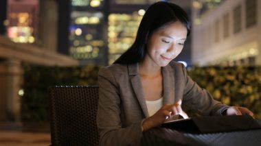 Geceleri tablet bilgisayar kullanarak iş kadını 