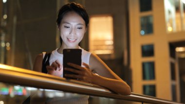 Geceleri cep telefonu kullanan bir kadın. 