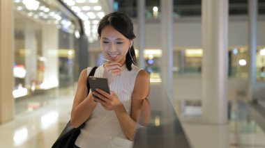 Alışveriş merkezinde Smartphone kullanan kadın