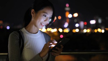 Şehirde Smartphone kullanan genç kadın 