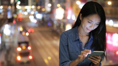 Geceleri cep telefonu kullanan bir kadın. 