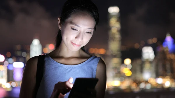 Nő nézi mobiltelefon éjjel — Stock Fotó