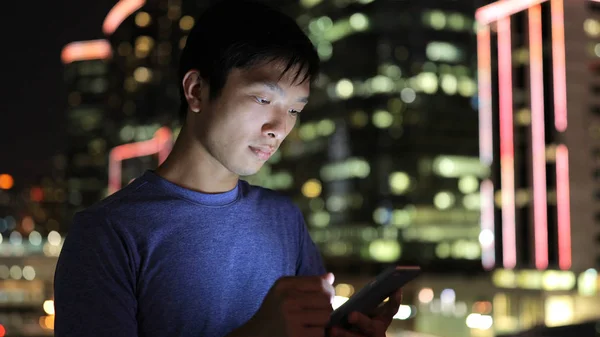 Hombre joven usando teléfono inteligente por la noche —  Fotos de Stock