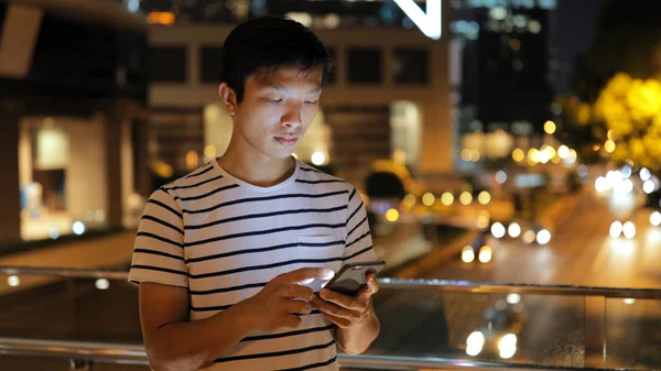 Hombre usando el teléfono móvil por la noche — Foto de Stock