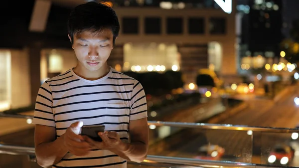 Geceleri cep telefonu kullanan adam. 