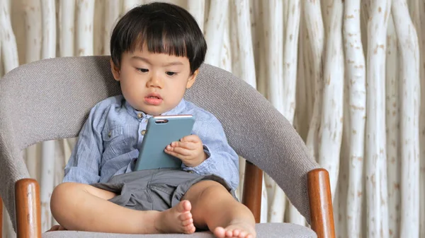 Asiatique garçon regardant smartphone — Photo