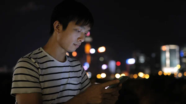 Hombre joven usando teléfono móvil — Foto de Stock