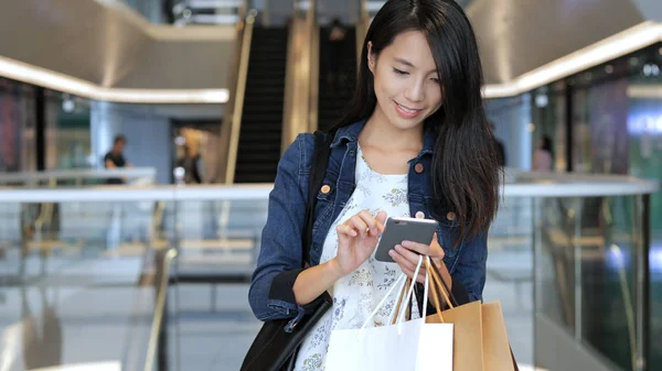 Kadın gitmek alışveriş ve taşımak çanta ve cep telefonu