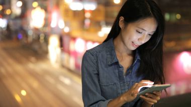 Gece akıllı telefon kullanan bir kadın.