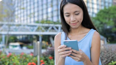 Kadın cep telefonuna bakıyor.