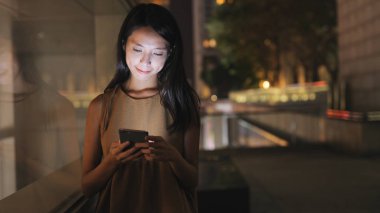 Geceleri cep telefonu kullanan kadın