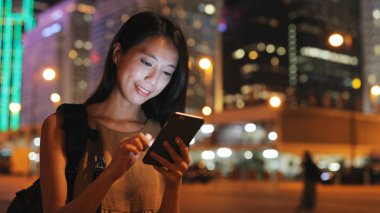 Şehirde akıllı telefon kullanan bir kadın 