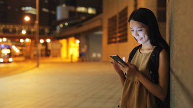 Şehirde akıllı telefon kullanan bir kadın. 