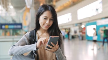 İstasyonda cep telefonu kullanan kadın