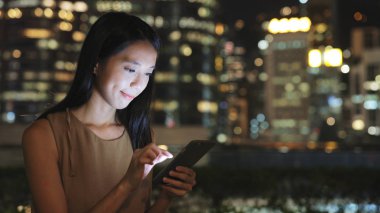 Geceleri cep telefonu kullanan bir kadın.