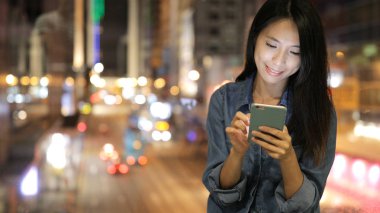 Geceleri cep telefonu kullanan kadın 