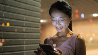 Geceleri cep telefonu kullanan kadın 