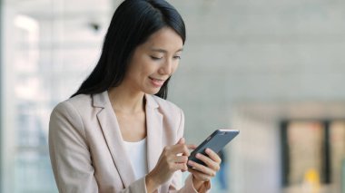 Ofiste cep telefonu kullanan iş kadını 