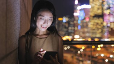 Şehirde akıllı telefon kullanan bir kadın.