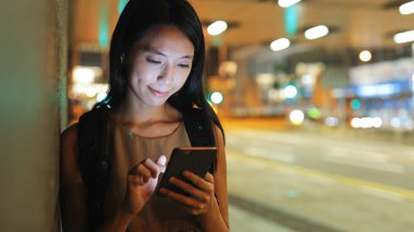 Akıllı telefon kullanan genç bir kadın.