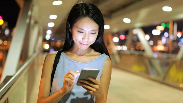 Vrouw met behulp van mobiele telefoon in de pedestrain-brug — Stockfoto